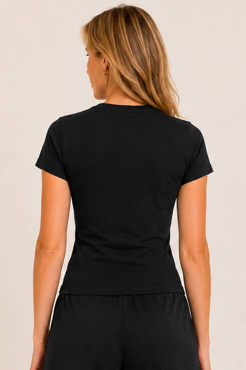 Woman wearing a black t-shirt and shorts set on a beige background